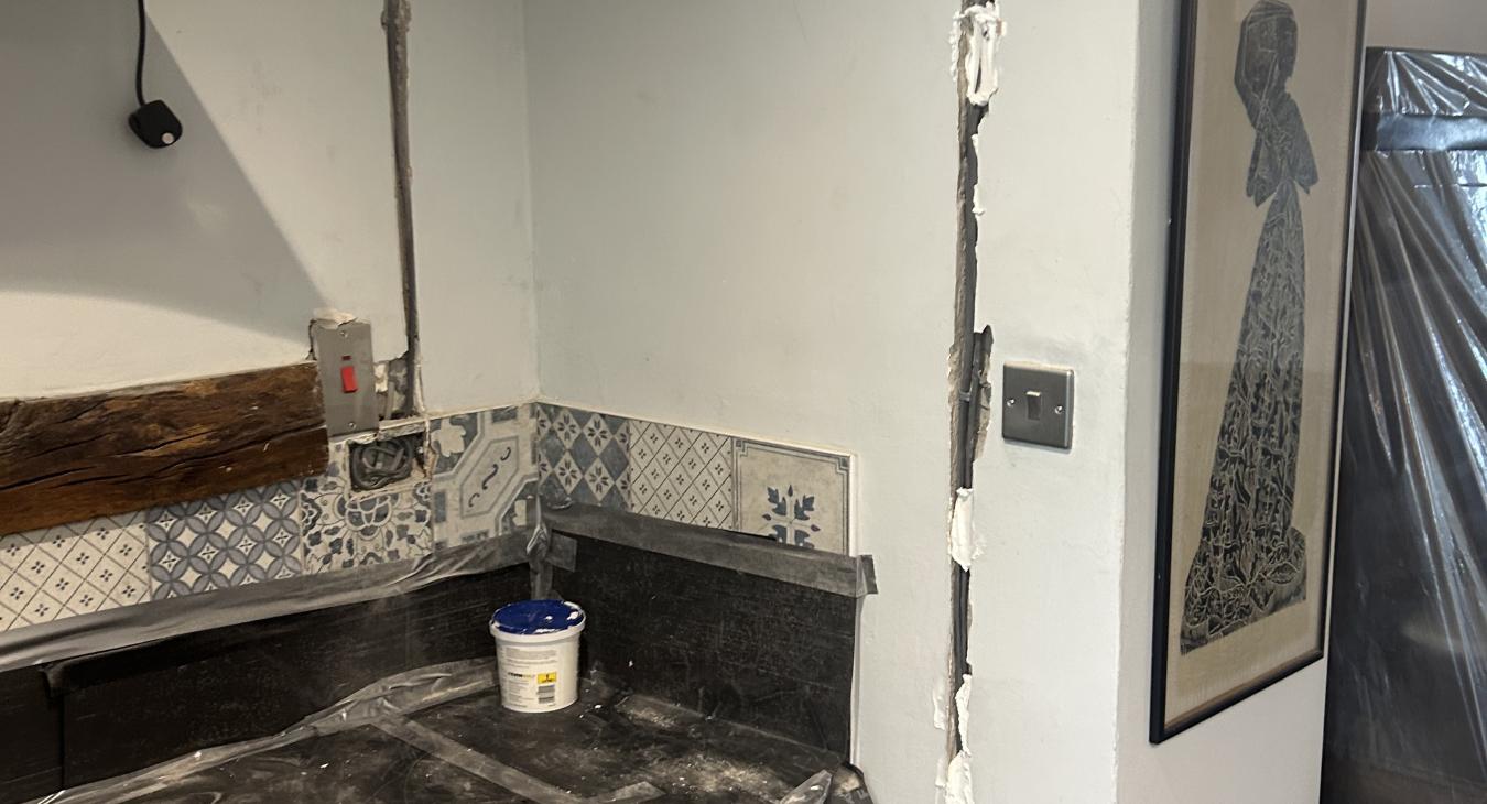 Wires chased in to the wall ,waiting to be plastered in and work tops protected.